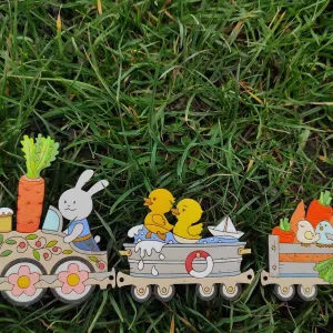 A wooden painted decoration of carrots, rabbits and ducks on a train.