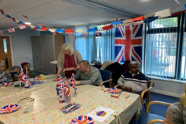 People sitting at a table with union jack flag in background