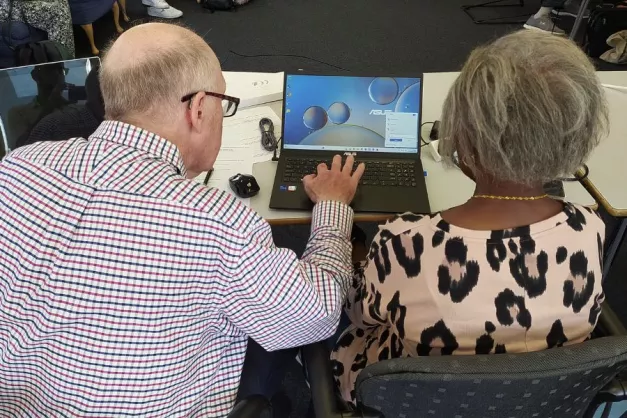 Image of two older people using a laptop