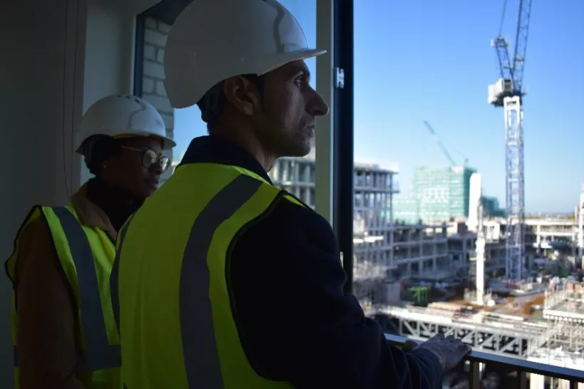 Councilor Ashan Khan looking out of a window at views of the new Coronation Square development 
