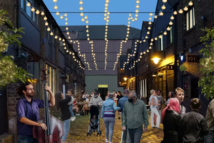 A computer generated image of Hatherley Mews with lots people walking in the early evening. You can see a person playing an instrument and lights over the Mews.