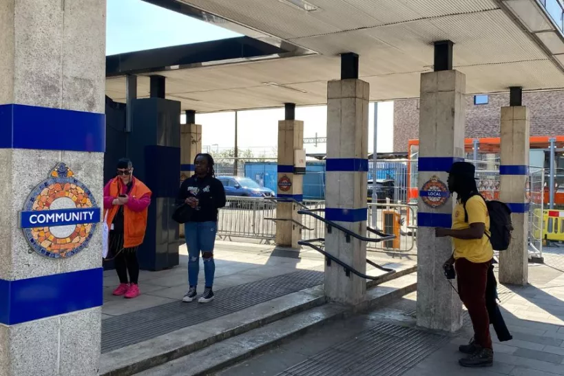 People look at the new Blackhorse Road Station Roundels displayed on pillars 