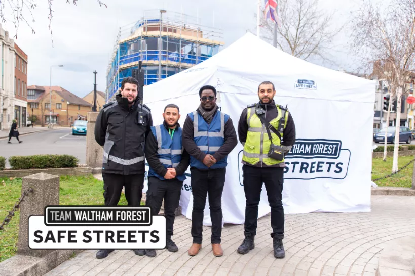 Four officers, one parking enforcement, one police and two from Safe Streets, stand in front of a marquee reading Team Waltham Forest: Safe Streets.
