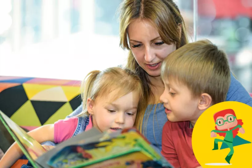 Woman is reading a book to children.