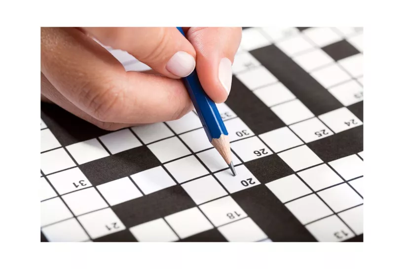 a photo of a person's hand doing a crossword