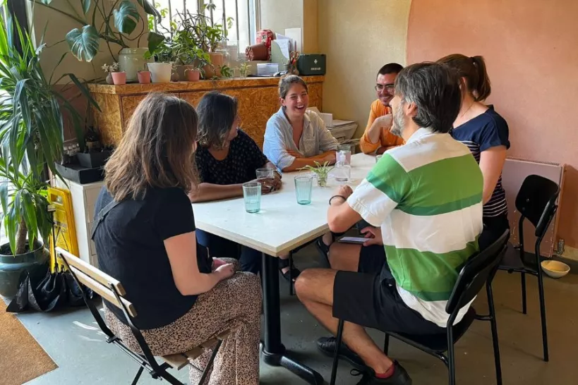 a group of adults around a table having a conversation about grief and loss at the Good Grief Café