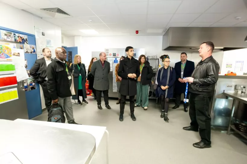 Headteacher of Belmont Park School Bruce Roberts showing councillors and council officers the kitchen facilities.