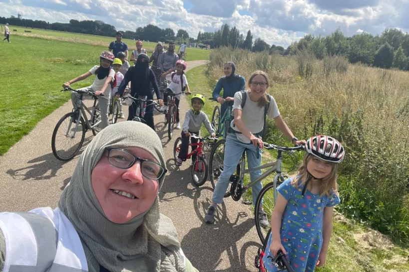 Photo of a group of people on bikes. Mariam is in the foreground on the left and the group behind her are made up of women and children.